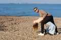 The couple is dancing, having fun and fooling around on the beach. A young bearded man in sunglasses hugs a girl by the Royalty Free Stock Photo