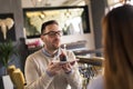 Couple celebrating birthday in restaurant, blowing candle on cake