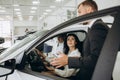 Couple and the dealer selling cars look the car in the showroom Royalty Free Stock Photo