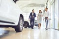 Couple and the dealer selling cars look the car in the showroom. Royalty Free Stock Photo