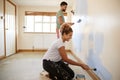 Couple Decorating Room In New Home Painting Wall Together