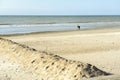 Couple on deserted beach looking at the sea on a sunny day