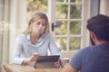 Couple With Digital Tablet Sitting At Table Working From Home Viewd Through Window Royalty Free Stock Photo