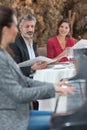 Couple dining listening to woman play piano Royalty Free Stock Photo