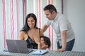 Couple works and watches laptop computer at home while baby takes mother`s breast Royalty Free Stock Photo