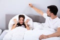 Couple disturbed by noise on bed Royalty Free Stock Photo