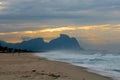 Couple and dog running on the beach of Barra da Tijuca in a beautiful dawn with the stone of Gavea in the background - Rio de Jane Royalty Free Stock Photo