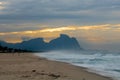 Couple and dog running on the beach of Barra da Tijuca in a beautiful dawn with the stone of Gavea in the background - Rio de Jane Royalty Free Stock Photo