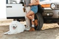 Couple with dog samoyed outdoors at beach near car Royalty Free Stock Photo