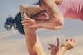 Close up of a young sporty couple practicing acroyoga exercises at sunrise or sunset.