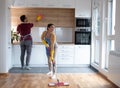 Couple doing chores together wiping dust and cleaning floor in their apartment Royalty Free Stock Photo