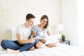 Couple Doing Online Shopping While Sitting On Bed Royalty Free Stock Photo