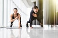 Fitness couple doing plank with one hand at the gym Royalty Free Stock Photo