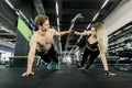 Couple doing pushups at training in gym. Young sporty couple working out together in a gym . Doing plank exercises while Royalty Free Stock Photo