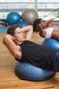 Couple doing sit ups on exercise balls Royalty Free Stock Photo