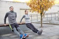 Couple doing triceps dip on city street bench Royalty Free Stock Photo