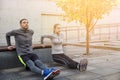 Couple doing triceps dip on city street bench Royalty Free Stock Photo