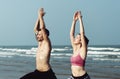 The couple is doing a yoga at the beach Royalty Free Stock Photo