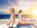 Couple doing yoga and cobra pose on beach Royalty Free Stock Photo