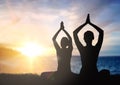 Couple doing yoga in lotus pose over sunset Royalty Free Stock Photo