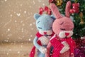 Couple dolls in a knitted scarf with Christmas tree background