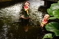 Couple dolls made of clay in pond at small garden. Royalty Free Stock Photo