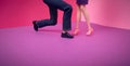 Couple, dolls. The man is standing on one knee. Pink purple background. Text space. Proposal, engagement, romance, concept. Royalty Free Stock Photo