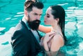 Couple in dress having Party in swimming pool. Celebrity couple, fashionable pair of elegant people. Romantic couple in