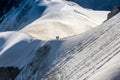 Couple dressed mountaineering clothes with backpacks rising arms with ice axes and enjoying views on the summit top near Aiguille Royalty Free Stock Photo