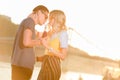 couple drinking beverage with two plastic straws from one bottle on river beach Royalty Free Stock Photo