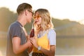 couple drinking beverage with two plastic straws from one bottle on river beach Royalty Free Stock Photo