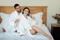Couple Drinking Champagne Sitting On Bed Enjoying Taste In Hotel Royalty Free Stock Photo