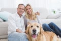 Couple drinking champagne with their dog in front of them Royalty Free Stock Photo
