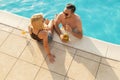 Couple drinking cocktails at a swimming pool Royalty Free Stock Photo