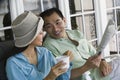 Couple drinking coffee and reading newspaper on porch Royalty Free Stock Photo