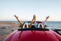 Couple driving convertible car near the ocean Royalty Free Stock Photo