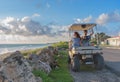 Couple driving a golf cart at tropical beach Royalty Free Stock Photo