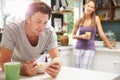 Couple Eating Breakfast Whilst Checking Mobile Phone Royalty Free Stock Photo