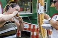 A couple is eating a burger sandwich at the Taste of the Kingsway Festival in Toronto