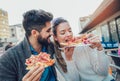 Couple eating pizza outdoors and smiling. Royalty Free Stock Photo