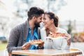 Couple eating pizza outdoors and smiling. Royalty Free Stock Photo