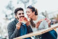 Couple eating pizza outdoors and smiling. Royalty Free Stock Photo