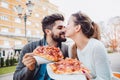 Couple eating pizza outdoors and smiling. Royalty Free Stock Photo