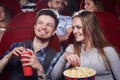 Couple eating popcorn at funny comedy in cinema. Royalty Free Stock Photo