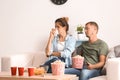 Couple eating popcorn while watching soap opera at home Royalty Free Stock Photo