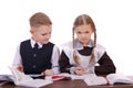 A couple of elementary school students sit at a desk