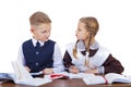 A couple of elementary school students sit at a desk