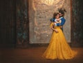 Couple embrace in room old castle. Happy beauty woman fantasy princess in yellow dress and guy is enchanted beast, horns Royalty Free Stock Photo