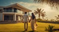 couple embracing in front of new big modern house, outdoor rear view back looking at their dream home Royalty Free Stock Photo