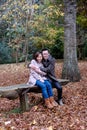 Couple embracing on park bench in autumn